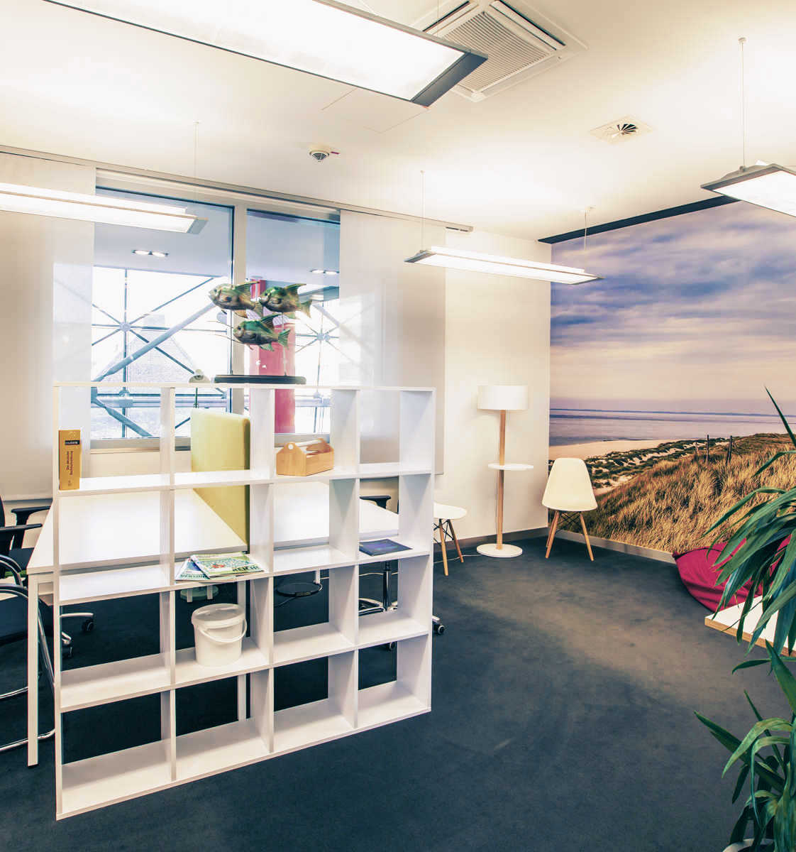 Coworking-Büro mit zwei Schreibtischen und Fototapete mit Motiv vom Strand